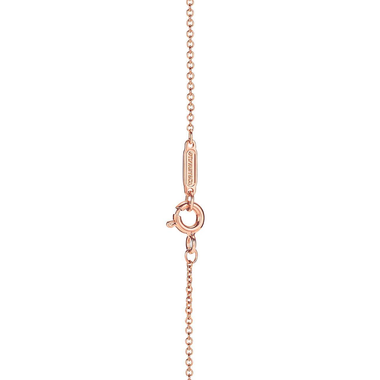 T*f*ny t diamond pendant in 18k rose gold with a baguette diamond