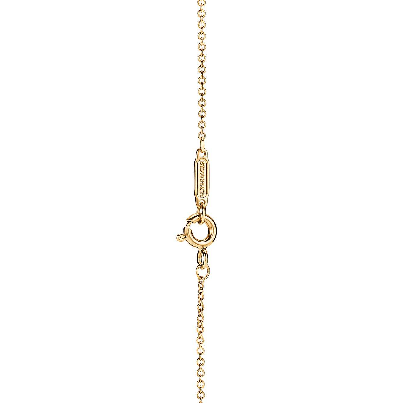 T*f*ny t diamond pendant in 18k gold with a baguette diamond